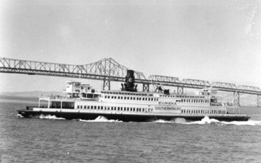 The EUREKA in action! The stately and venerable sidewheeler has met a train from the East at Oakland Pier. Passengers, baggage, express and mail ticketed for San Francisco completed their journey in style. After July 30, 1958 Greyhound buses will handle transbay chores, a move deemed way cool by SP cost accountants.  (SF Maritime Museum photo courtesy of Dave Givens)